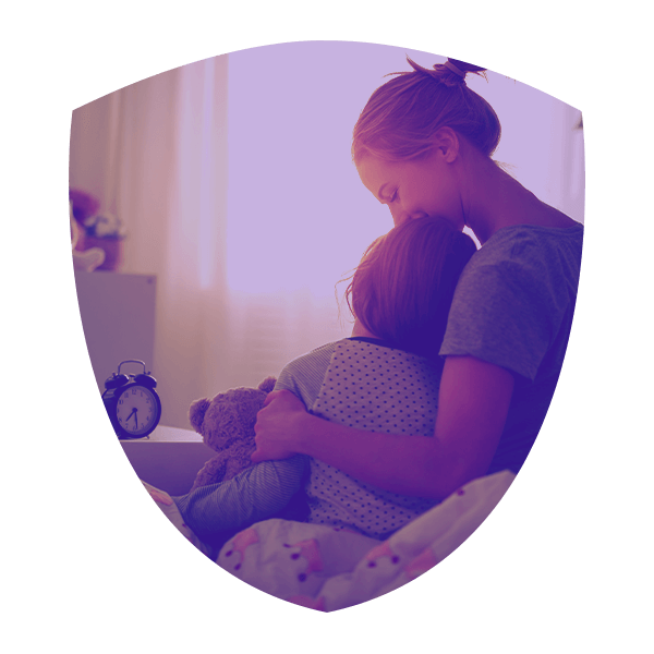 Woman holding her son in his bed