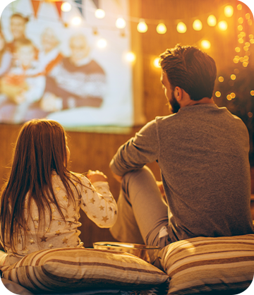 Father and daughter watching a movie outside