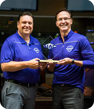 Guardian team members holding Monitoring Center award